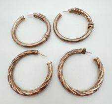 2 pairs of large silver hoop earrings. A pair of twist design hoops together with a pair of plain