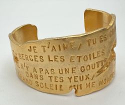 A gold plated LancÃ´me Poeme bangle inscribed with the poem Ode to love. Made for the launch of