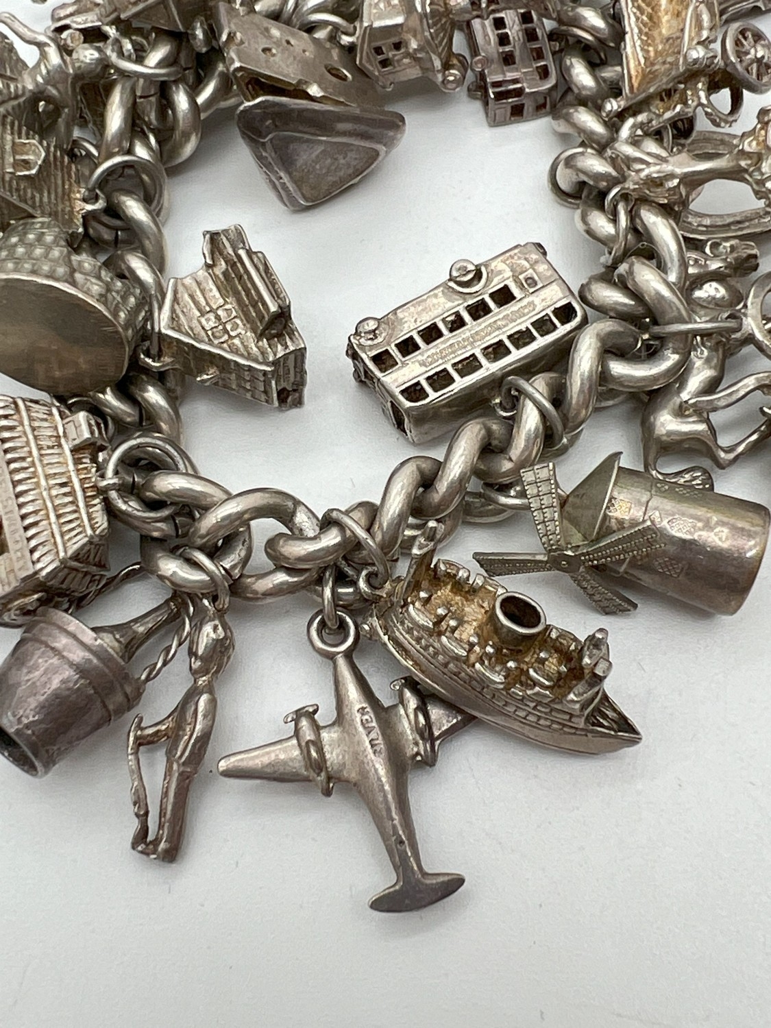 A vintage silver charm bracelet with large padlock clasp and 29 silver and white charms - some - Image 4 of 8