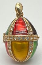 A yellow metal harlequin enamelled pendant, modelled as an egg, with clear stone set detail. With