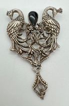A large vintage silver pierced work brooch with peacock design, set with teardrop shaped black
