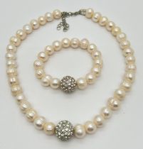 A large freshwater pearl and crystal set ball necklace with matching stretch bracelet by Akss,