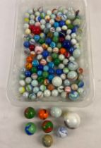 A collection of vintage Aggie style marbles in various sizes, some with iridescent finish. In both