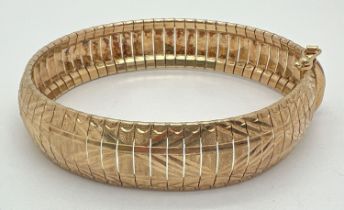 An Italian gold on silver flexible bracelet with bright cut engraved design to each link. Approx. 8"