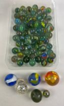 A collection of 70+ vintage bowler, jumbo and super jumbo glass marbles to includes Cats Eye,