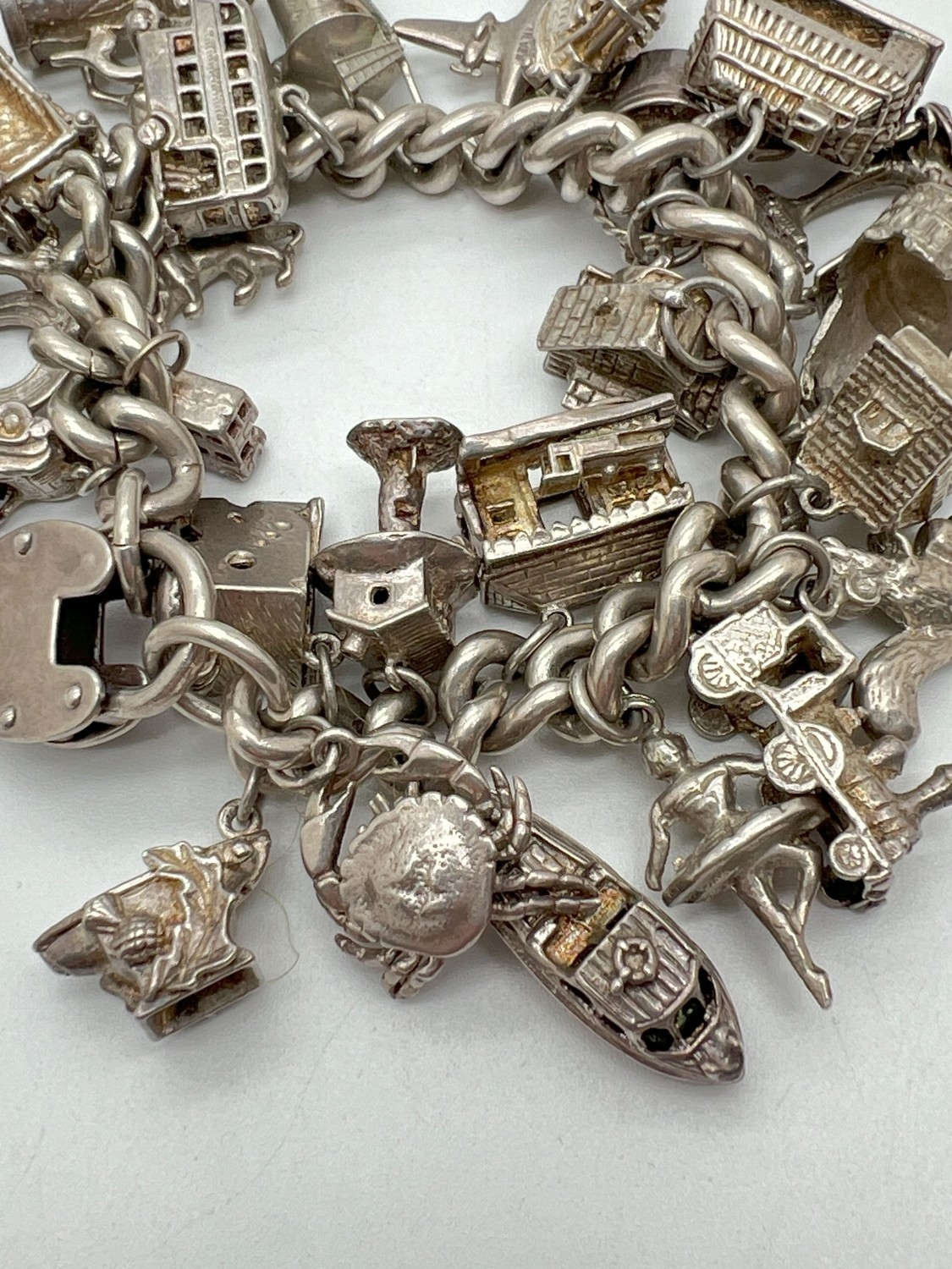 A vintage silver charm bracelet with large padlock clasp and 29 silver and white charms - some - Image 6 of 8