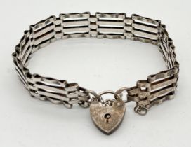 A vintage silver 4 bar gate bracelet with padlock and safety chain. Floral decoration to front of