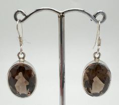 A pair of 925 silver drop earrings set with large oval faceted smoked quartz stones. Hooked posts