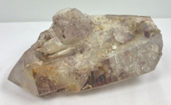 A large 7.8 kg double terminated smoked quartz crystal point with hematite inclusions and multiple