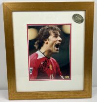 A framed and glazed signed photograph of Manchester United footballer Ruud Van Nistelrooy,