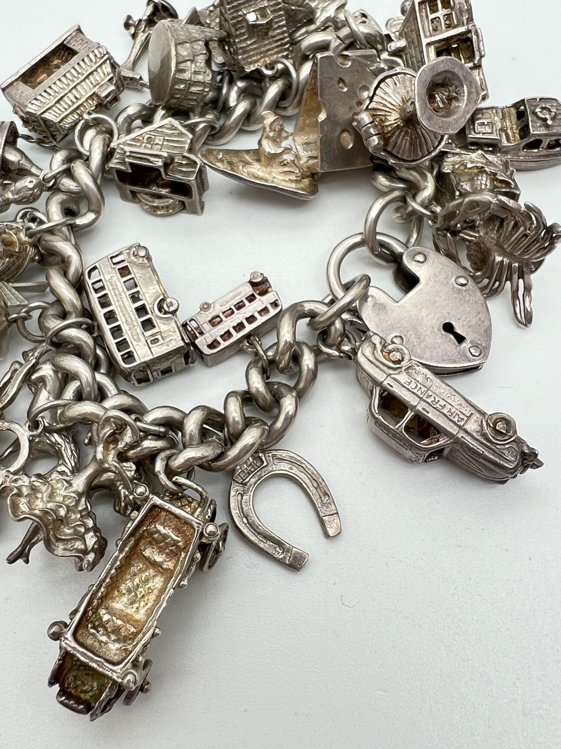 A vintage silver charm bracelet with large padlock clasp and 29 silver and white charms - some - Image 2 of 8