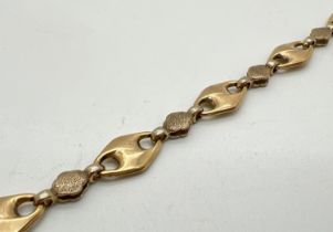 A 9ct gold 8" mariners and brushed gold link bracelet with lobster claw clasp. Gold marks to clasp