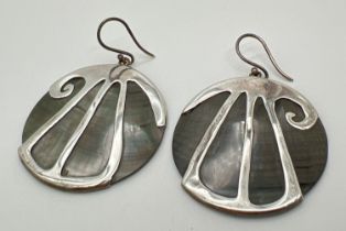 A pair of large circular shaped Abalone shell drop style earrings with silver overlay design. Marked