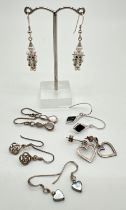 6 pairs of silver and white metal drop style earrings. To include open hearts, Celtic knots,