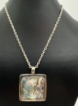 A large silver, square shaped modern design pendant set with abalone shell and faceted quartz. On