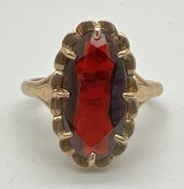 A vintage 9ct gold garnet dress ring. A large oval cut claw set garnet set in a decorative pierced