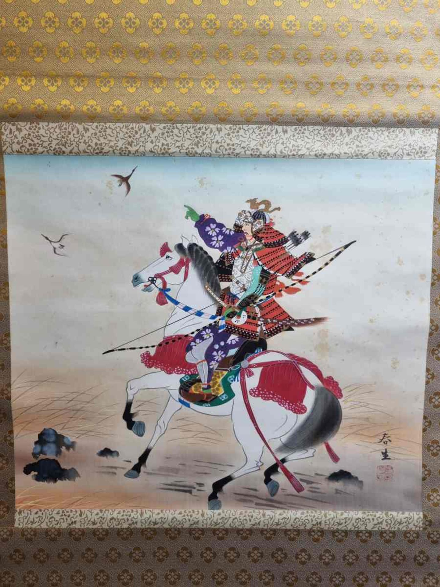 Samurai auf weißem Pferd gen Himmel weisend