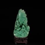 An emerald jade carving group of a figure in a mountain, W 13,5 cm - H 25 cm - Total H 29.5 cm