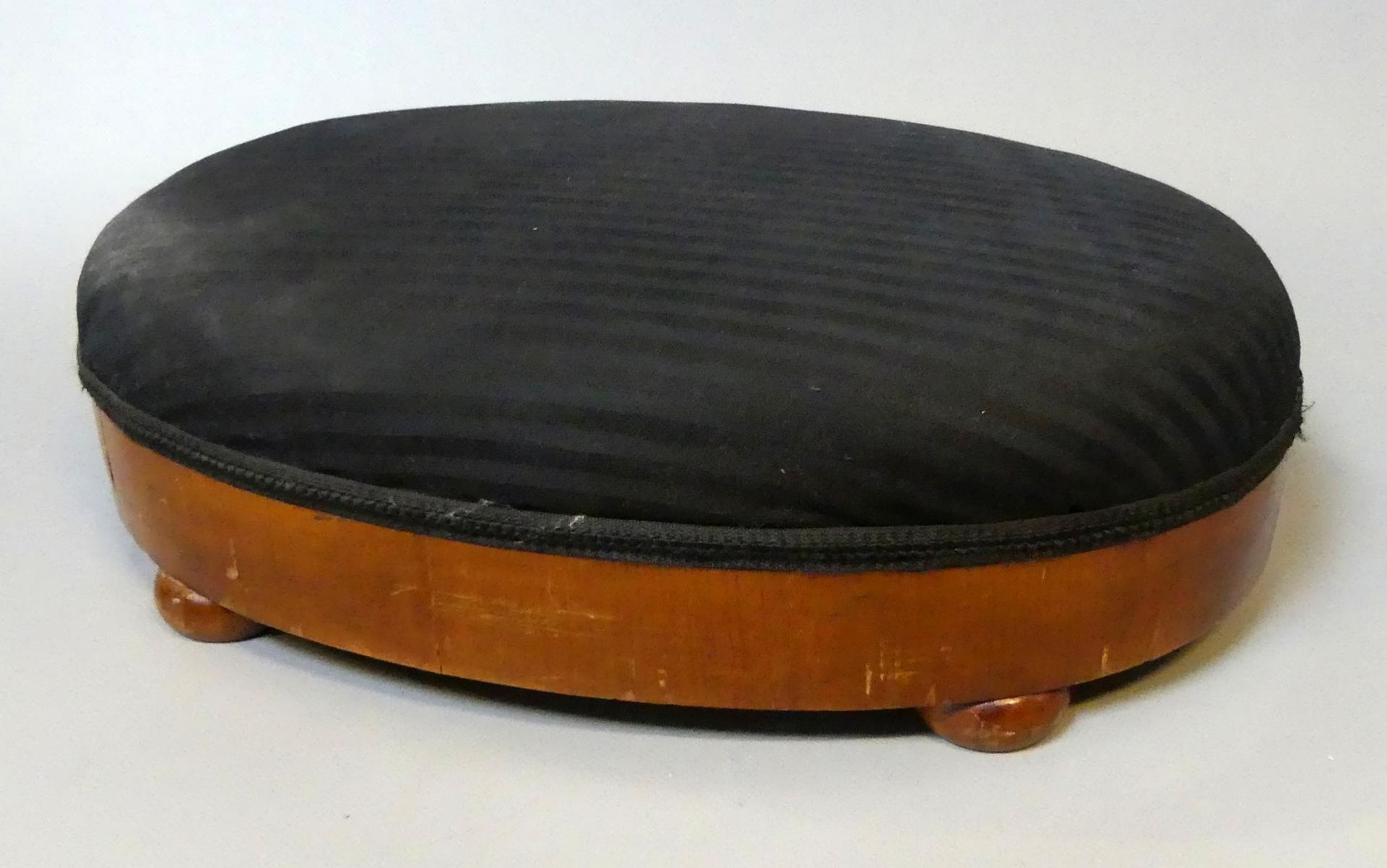 Fußhocker, oval, Kirschbaum, schwarzer Stoffbezug, H.ca. 12, B. 42, T. 28 cm