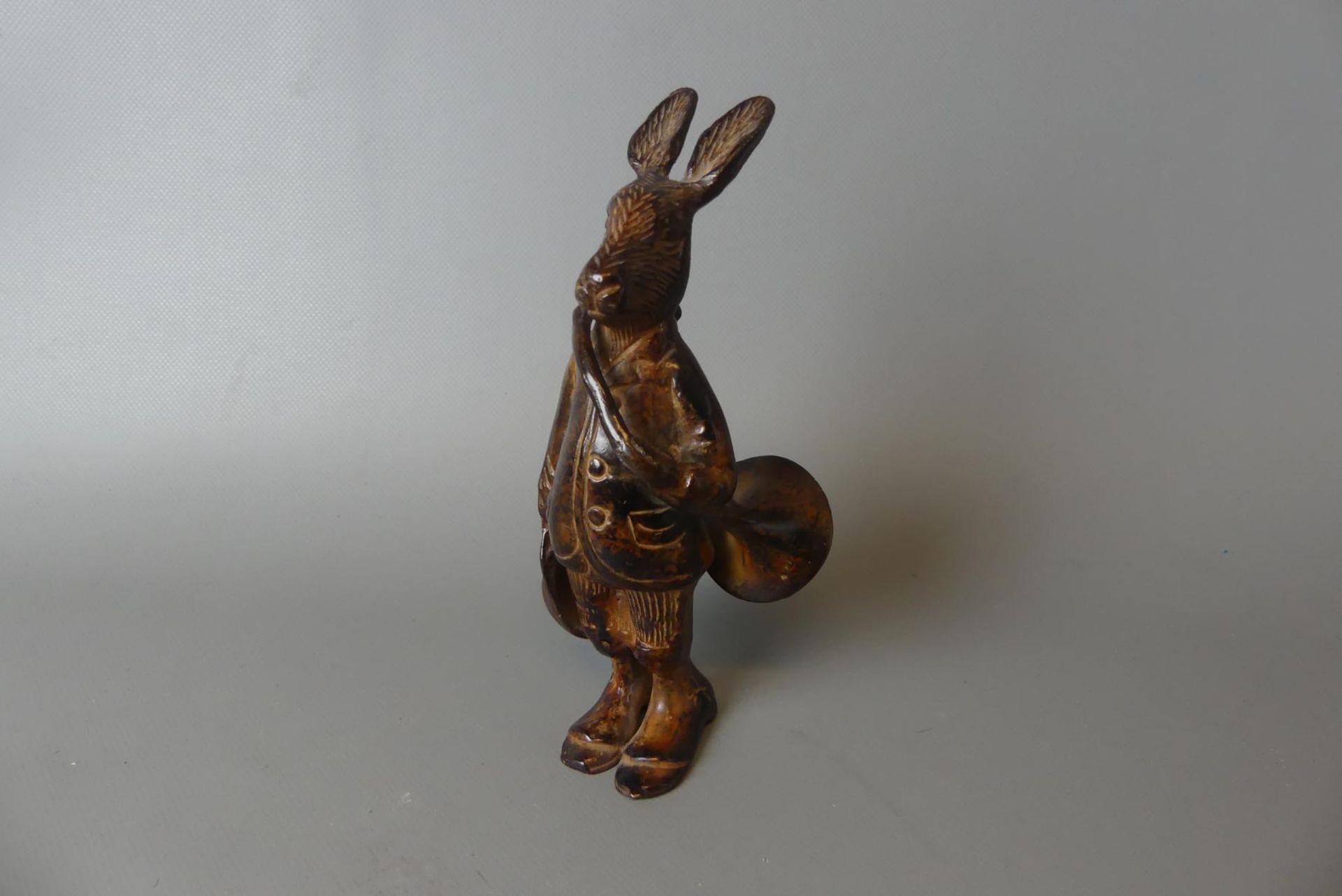 Stehender Hase mit Musikinstrument und Kappe haltend, Bronze,