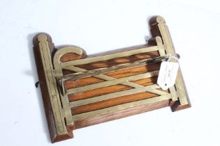 Victorian novelty oak and brass pipe rack, modelled as a six bar gate, with five recesses for pipes,