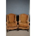 Pair of George III style wing back armchairs,the chairs upholstered in a orange fabric with a