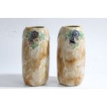 Pair of Royal Doulton stoneware vases, each with tubelined flowers on a brown mottled ground,