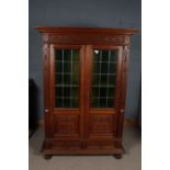 Early 20th century Dutch oak bookcase, having a pair of green and leaded glazed doors enclosing