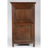 An early 18th century oak upright cupboard, French With two cut-corner and fielded panelled doors,