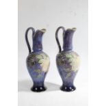 Pair of Royal Doulton ewers, the baluster shaped ewer with a long slender neck and a scroll carrying