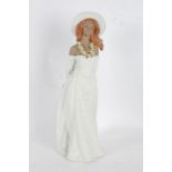 Tall Lladro stoneware figurine, in the form of a lady in white dress and hat, with flower