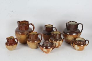 Six Royal Doulton stoneware jugs, together with a teapot and sugar bowl, in the harvest pattern (8)