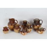 Six Royal Doulton stoneware jugs, together with a teapot and sugar bowl, in the harvest pattern (8)