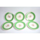 Set of Six Wedgwood plates decorated with a floral scene to the center and a green and golden