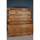 Large stripped pine dresser, fitted five small drawers to the rack, four drawers to the base above