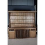 Large Early 20th century pine dresser and rack, the rack with three plate racks above a cupboard