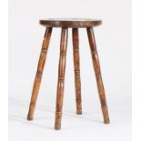 Elm stool/candle stand, the circular seat raised on four turned legs, 33cm diameter, 55.5cm high