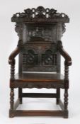 An unusual oak Wainscot chair, of large proportions, the carved pediment with a moustached gentleman