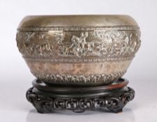 A late 19th/early 20th century Burmese white metal bowl, with repousee frieze depicting hunters on