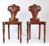 A pair of Regency mahogany hall chairs, carved scrollwork backs, shaped and dished solid seats,