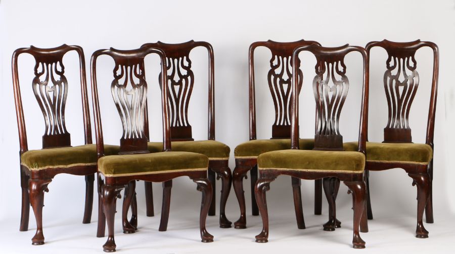 A set of six George III cherry wood dining chairs, the scroll undulating top rail above a wide