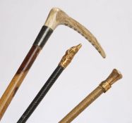 Fine gilt metal riding crop, the terminal modelled as a dogs head above scrolls, 54cm long, Swaine &