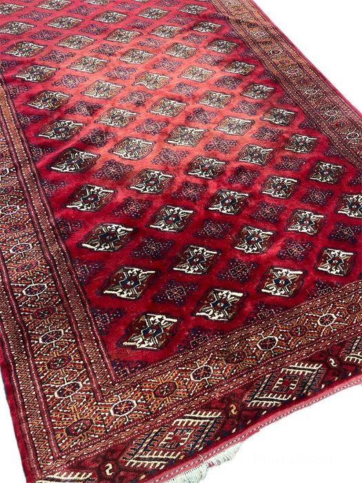 A Tekke Turkoman rug, the scarlet red field with five rows of tribal guls, multiple borders, 320cm x