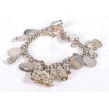 Silver and white metal charm bracelet, set with various charms to include boats, bike etc, weight