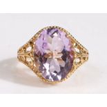 A 9 carat gold gem-set ring, featuring a pretty large oval cut pinkish-purple gem mounted on a