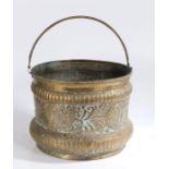 A brass repouseé log basket With swing handle and floral decoration, 40cm diameter, 31cm high to