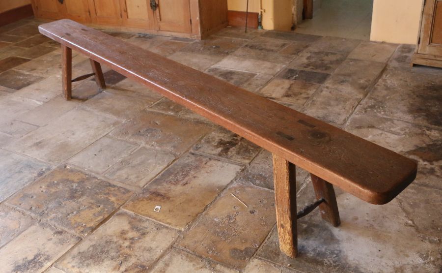 A Victorian pitch pine bench, circa 1840 Having a deep, one-piece rounded rectangular top, with