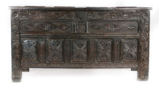 A Charles II joined oak coffer, Cumbria Having a quadruple-panelled hinged lid, the front with a
