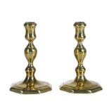 A pair of Queen Anne/George I brass socket candlesticks, circa 1715 Each with moulded waisted