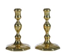 A pair of Queen Anne/George I brass socket candlesticks, circa 1715 Each with moulded waisted